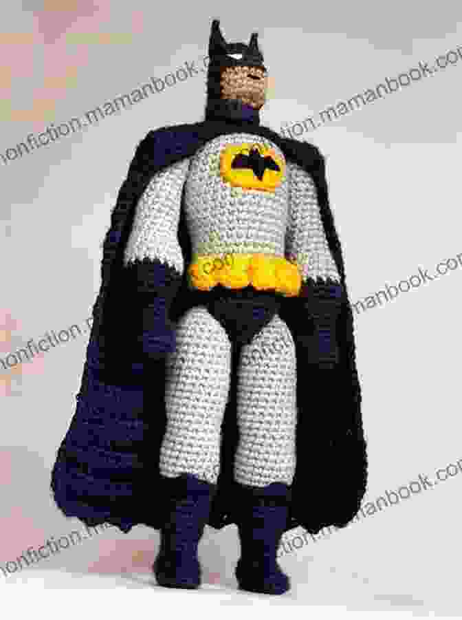 A Crocheted Batman Doll Wearing A Black Cape And Cowl, With Yellow Utility Belt And Bat Symbol On His Chest Crochet Batman Pattern
